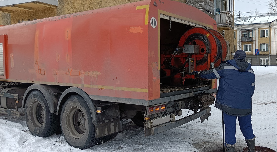 Каналопромывочная машина и работник прочищают засор в канализационной системе в Кирсанове